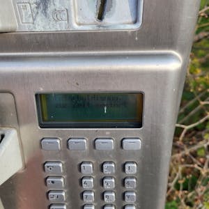 Öffentliches Telefon mit der Anzeige „Entschuldigung, zur Zeit gestört“
