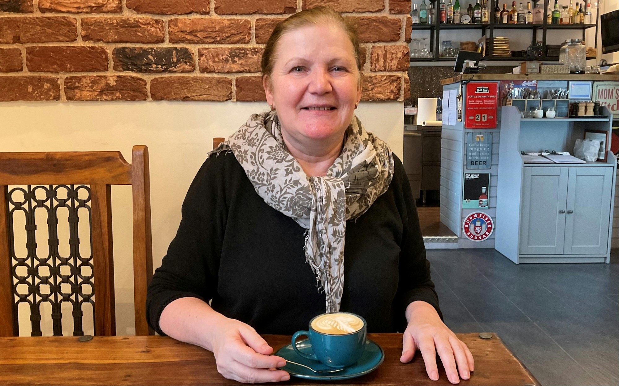 Frau im Café mit einer Tasse Cappuccino