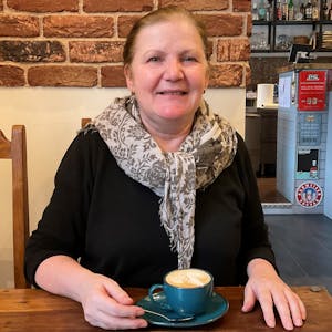 Frau im Café mit einer Tasse Cappuccino