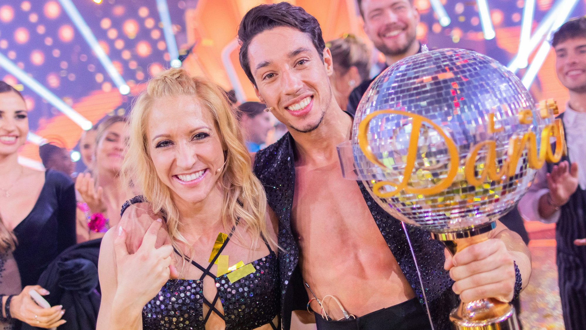 René Casselly, Zirkusartist, und Kathrin Menzinger, Profitänzerin, jubeln mit dem Pokal nach dem Sieg in der RTL-Tanzshow „Let's Dance“ im Coloneum, hier im Mai 2022 in Köln.