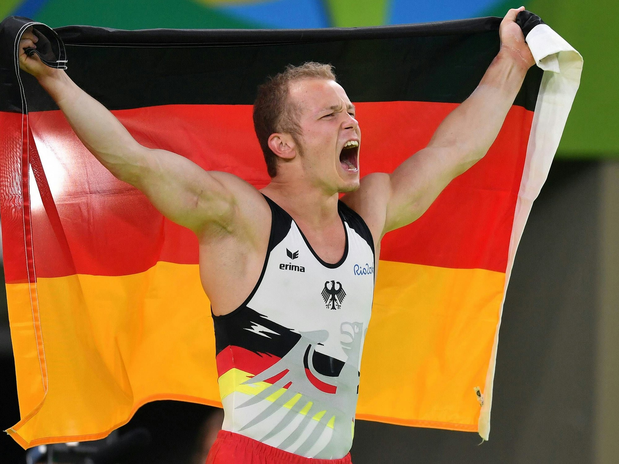 Fabian Hambüchen jubelt mit der Deutschlandfahne über seinen Olympiasieg.