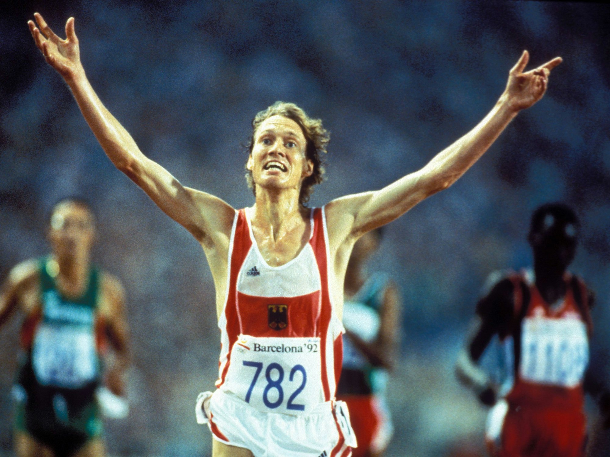 Dieter Baumann jubelt, mit beiden Händen in die Höhe gestreckt, über seinen Olympia-Sieg 1992 über 5000 Meter.