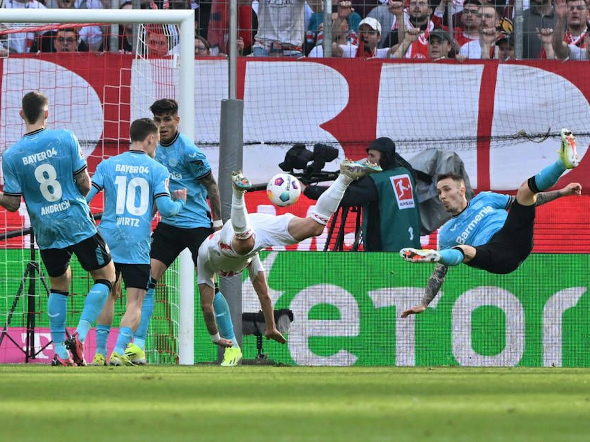 Alejandro Grimaldo (Bayer 04 Leverkusen) und Sargis Adamyan (1. FC Köln) fliegen durch den Strafraum.