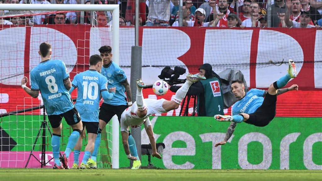 Alejandro Grimaldo (Bayer 04 Leverkusen) und Sargis Adamyan (1. FC Köln) fliegen durch den Strafraum.