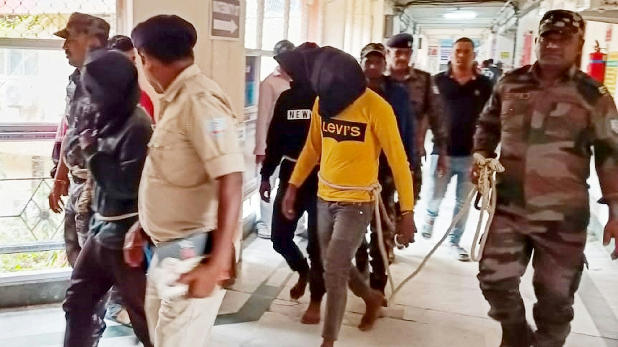 Polizeibeamte eskortieren am 4. März 2024 Männer, die beschuldigt werden, eine Spanierin brutal vergewaltigt zu haben, zu einem Bezirksgericht in Dumka im indischen Bundesstaat Jharkhand.