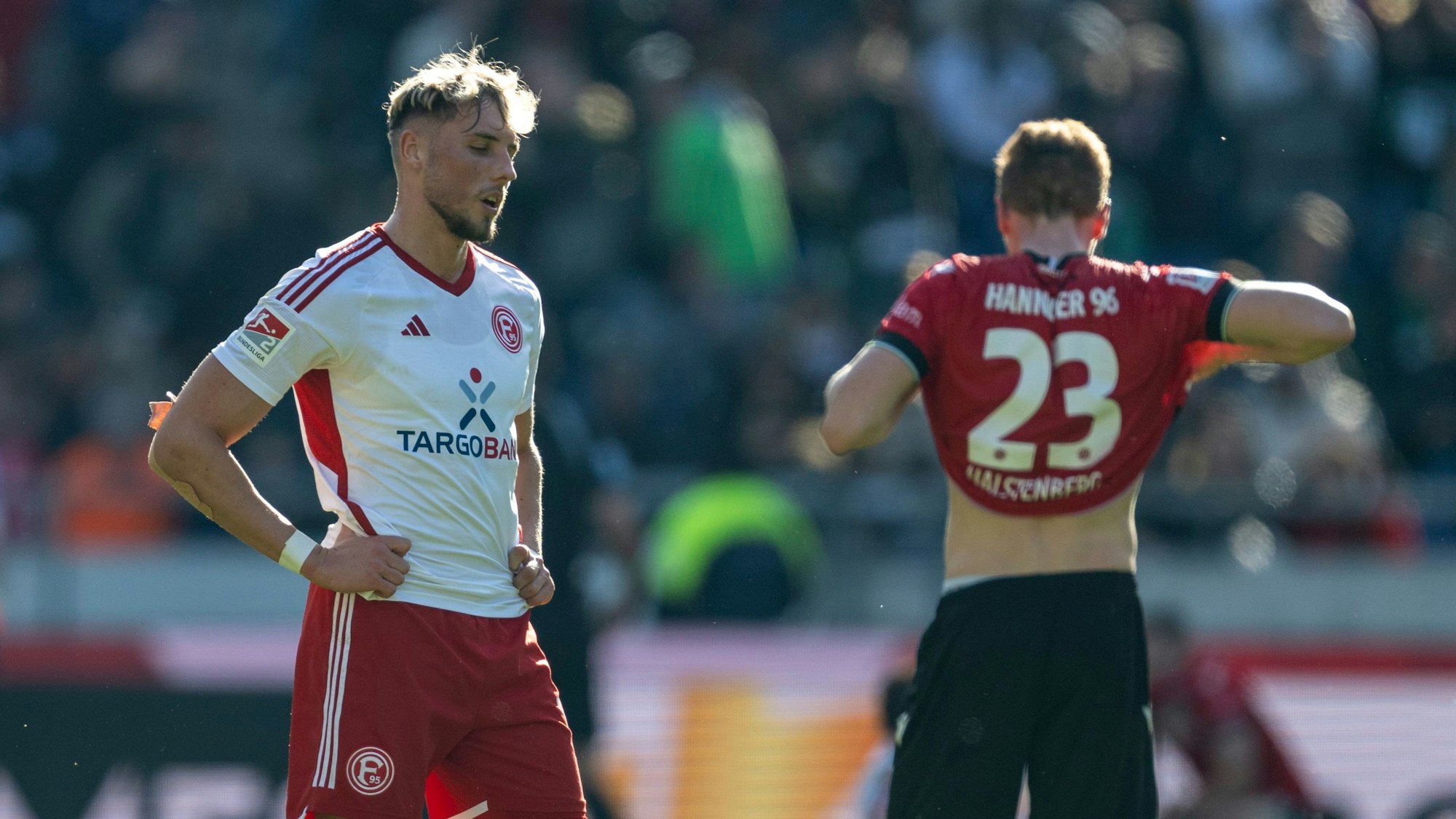 Fortuna Düsseldorfs Jona Niemiec steht nach dem Schlusspfiff in Hannover enttäuscht auf dem Rasen.