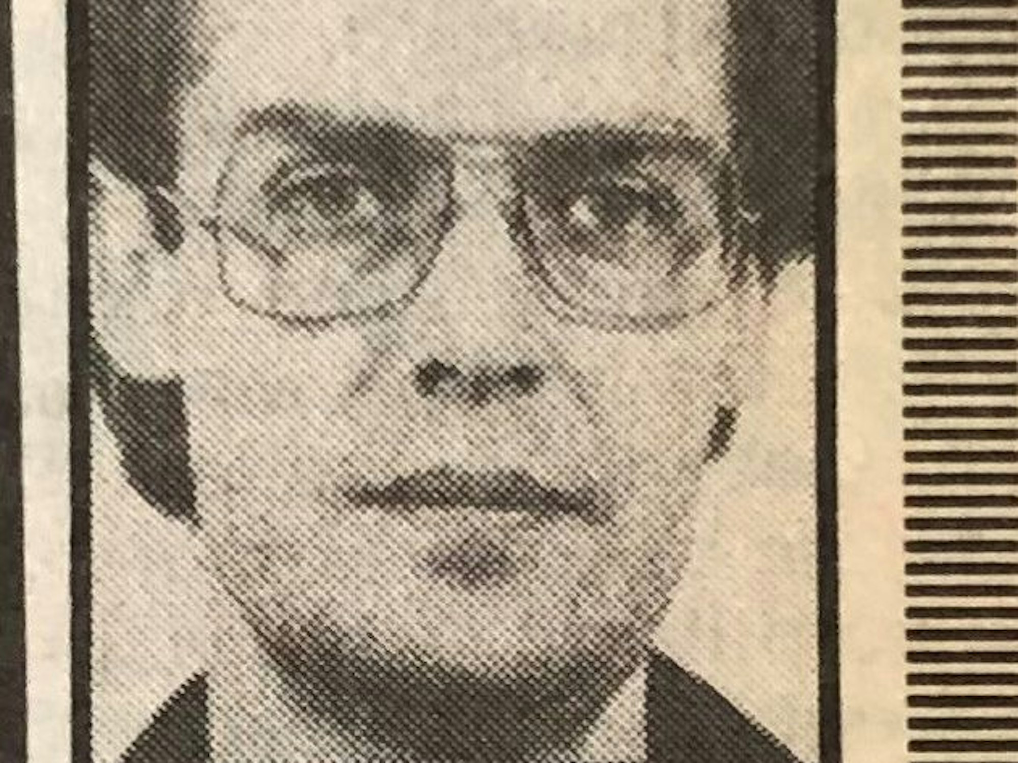 Das Porträt eines Mannes mit Brille ist in einem uralten Zeitungsartikel zu sehen.