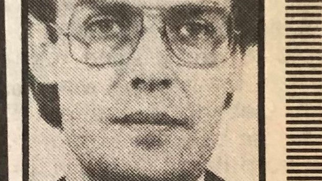 Das Porträt eines Mannes mit Brille ist in einem uralten Zeitungsartikel zu sehen.