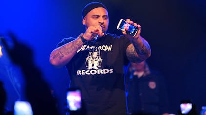 Rapper Massiv hält 2013 bei einem Konzert in Mannheim ein Handy in die Kamera.