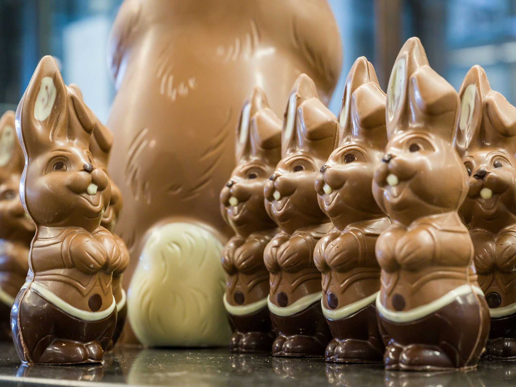 Lachende Osterhasen aus Schokolade stehen auf einem Tisch. Das Foto wurde 2021 in Brandenburg aufgenommen.