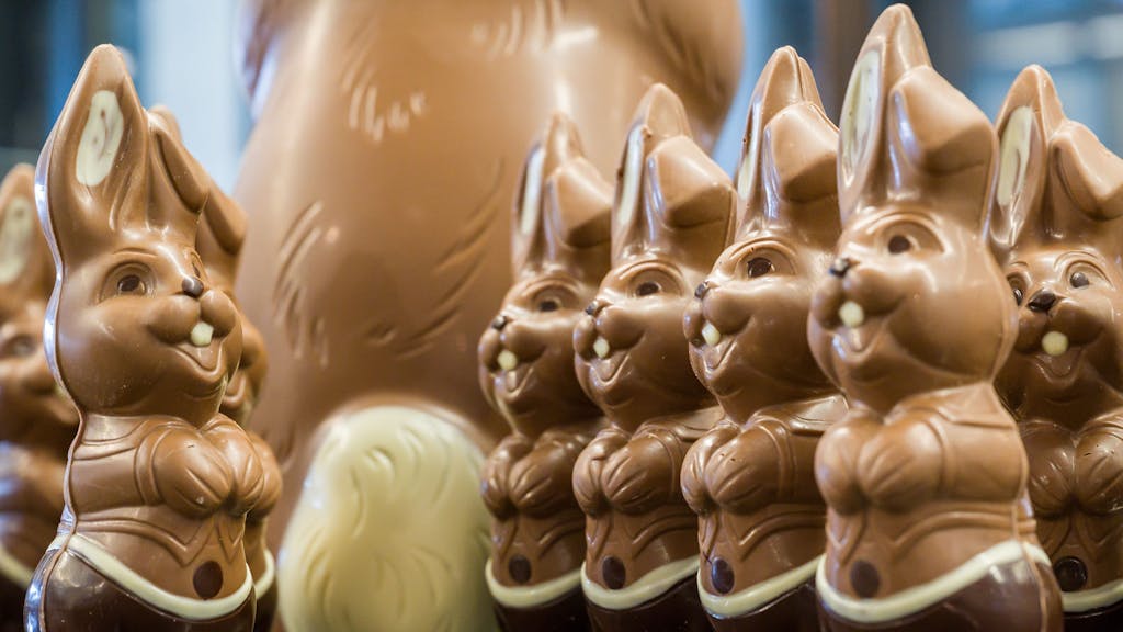 Lachende Osterhasen aus Schokolade stehen auf einem Tisch. Das Foto wurde 2021 in Brandenburg aufgenommen.