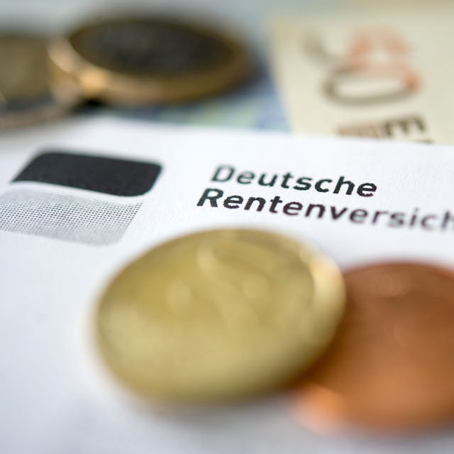 Auf einem Zettel ist das Logo der Deutschen Rentenversicherung zu sehen. Einige Centstücke und Geldscheine liegen auf und unter dem Papier.