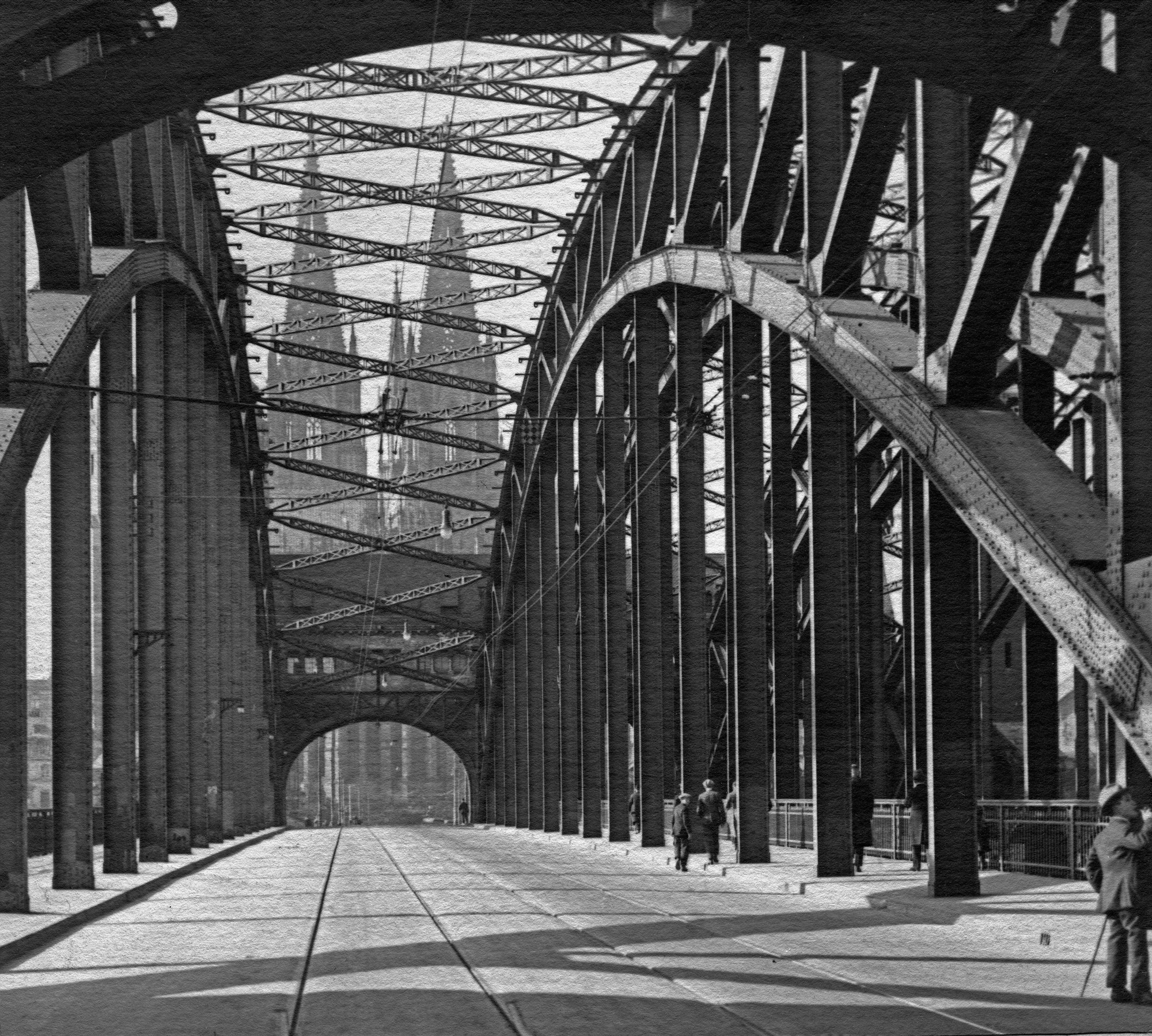 Blick durch die Stahlkonstruktion der Hohenzollernbrücke auf den Ostchor des Kölner Doms. Das Aufnahmedatum ist in den 1920er Jahren.