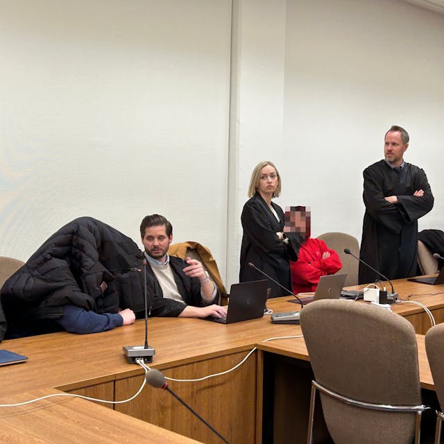 Zu sehen sind sechs Menschen in einem Gerichtssaal.