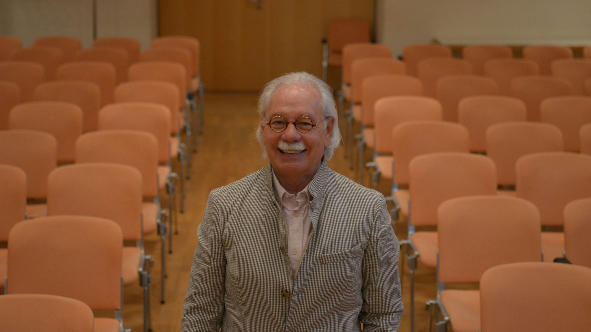 Klaus Linden steht im Comedia-Konzertsaal, hinter ihm leere Sitzreihen.