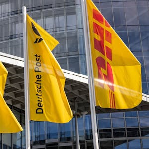 Flaggen der Deutschen Post und der DHL Group wehen vor der Zentrale der Deutschen Post.