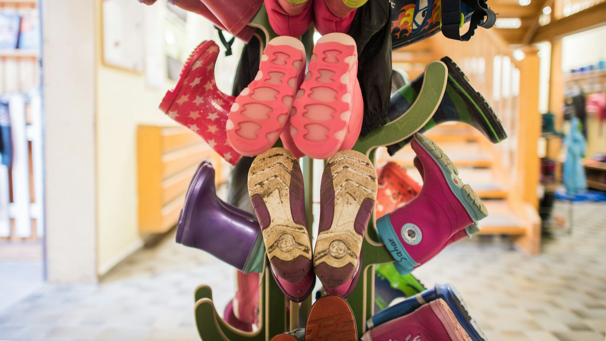 Gummistiefel für Kinder sind an einer Garderobe in einer Kindertagesstätte zu sehen.