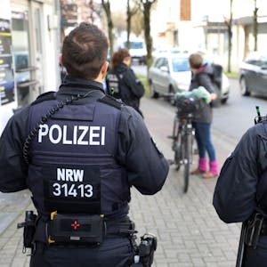 Polizeibeamte und -beamtinnen der Bereitschaftspolizei kontrollieren eine Fahrradfahrerin in Bergisch Gladbach.