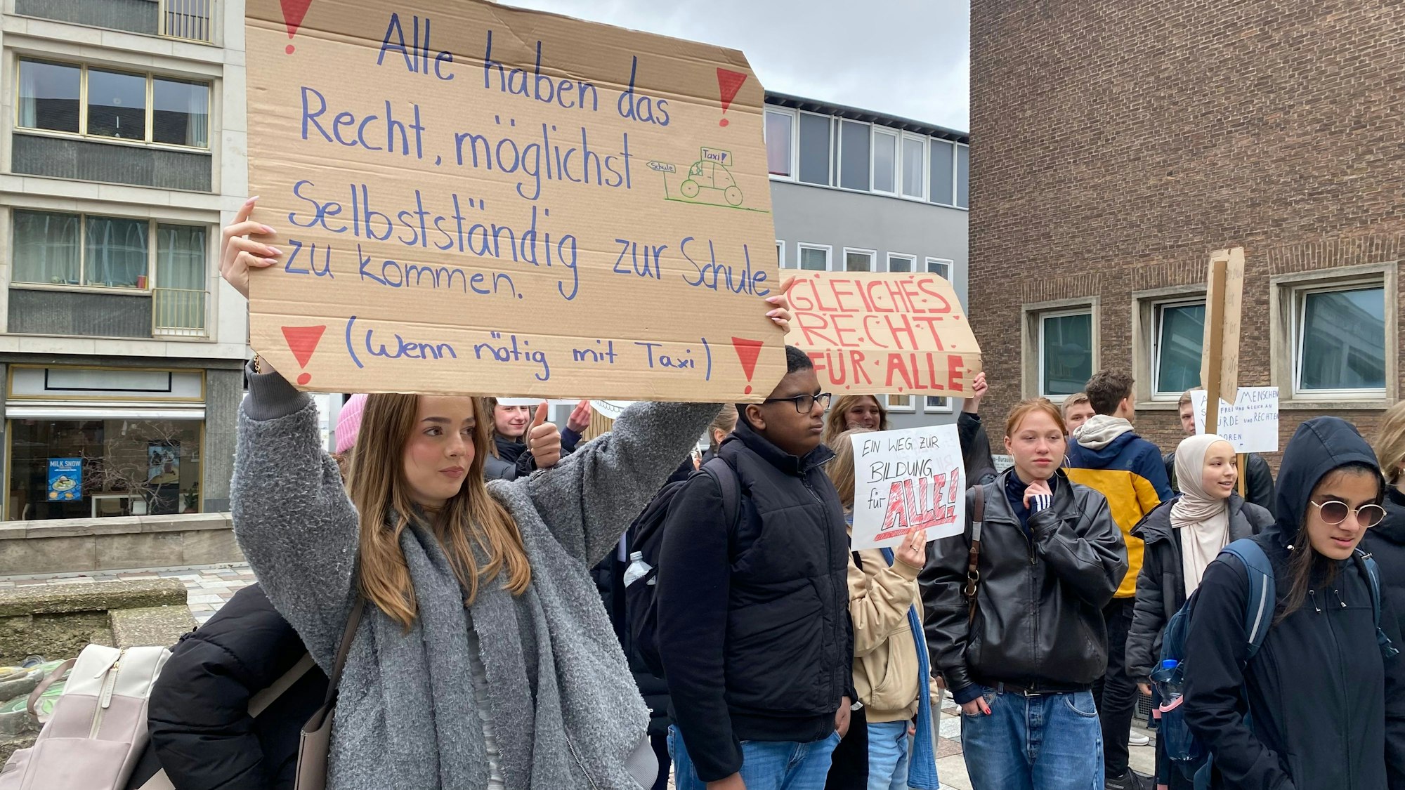 Demonstrierende Schüler halten ein Plakat hoch.