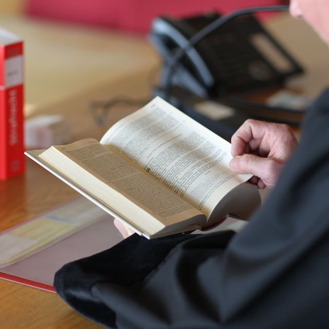 Ein Richter an seinem Tisch mit einem Buch&nbsp;