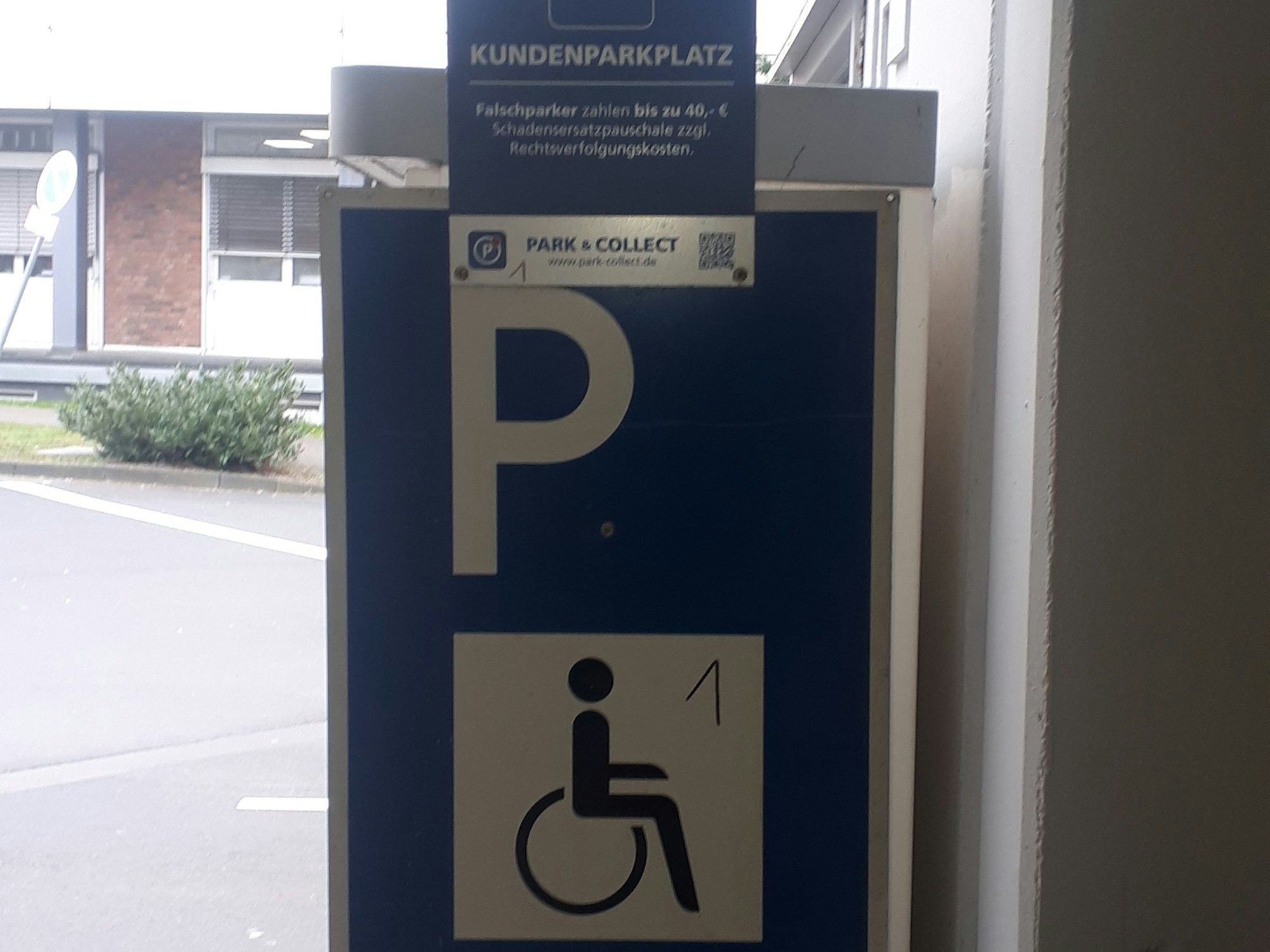 Ein Parkschild mit Rollstuhl-Piktogramm ist zu sehen.