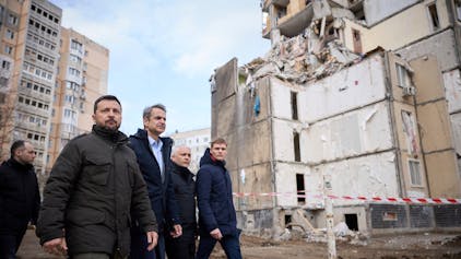Wolodymyr Selenskyj (l), Präsident der Ukraine, und Kyriakos Mitsotakis (M), Ministerpräsident von Griechenland, gehen durch ein von einem russischen Angriff beschädigtes Wohngebiet in Odessa.