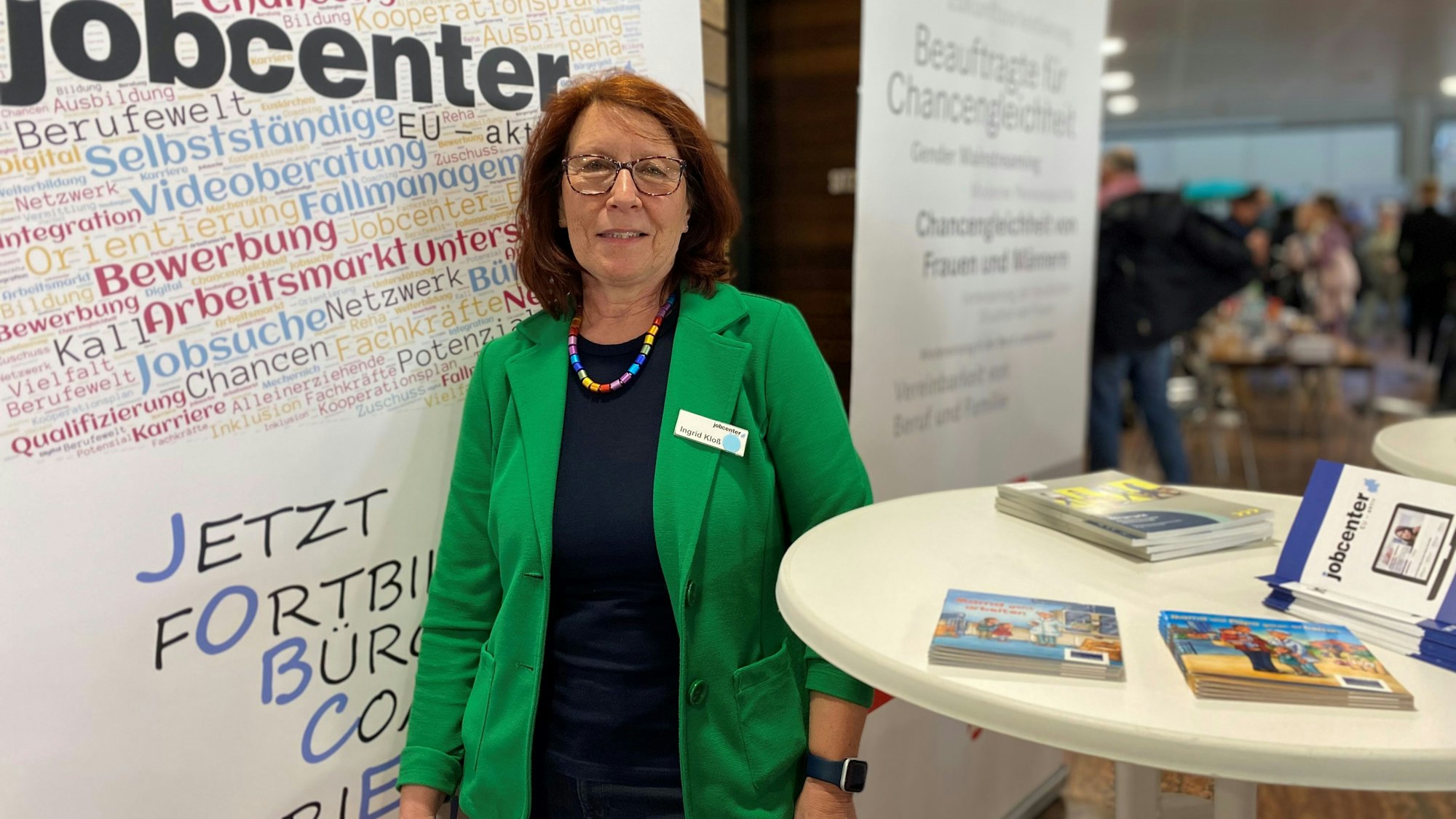 Ingrid Kloß, Beauftragte für Chancengleichheit im Jobcenter Euskirchen steht an ihrem Stand zwischen zwei Plakaten