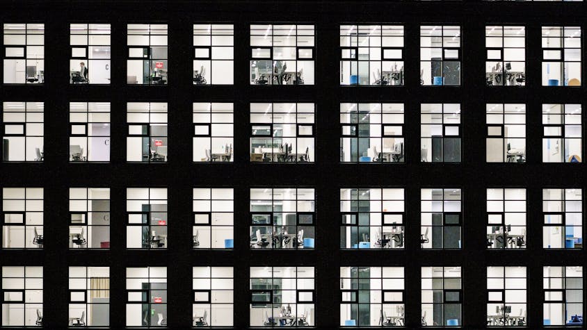 Büros in einem Gebäude im Europaviertel sind hell erleuchtet. (Archivbild)