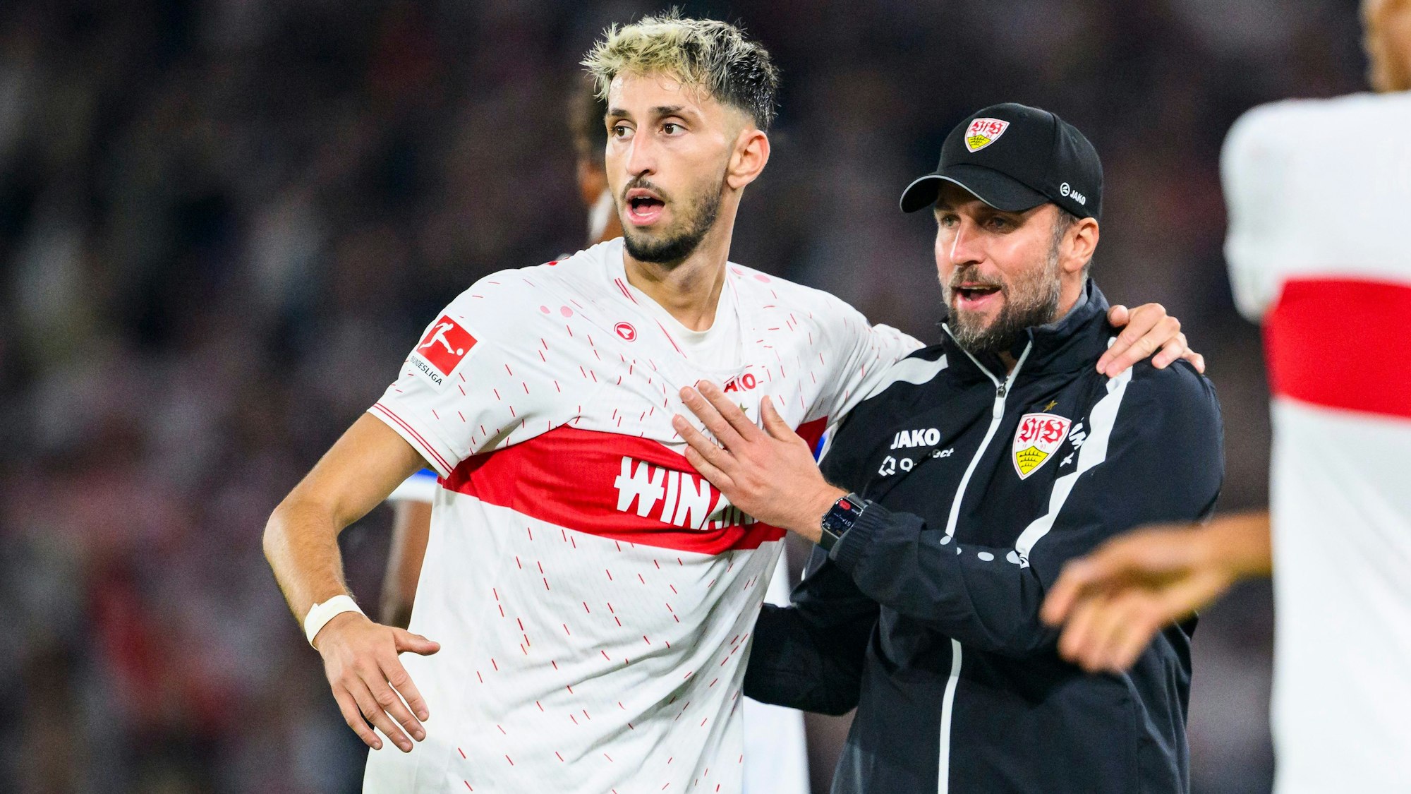 Stuttgarts Trainer Sebastian Hoeneß (r.) jubelt nach dem Spiel mit seinem Profi Atakan Karazor (l.).
