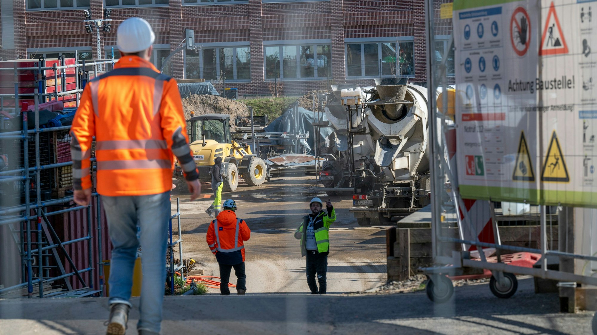 Bauarbeiter laufen über die Baustelle