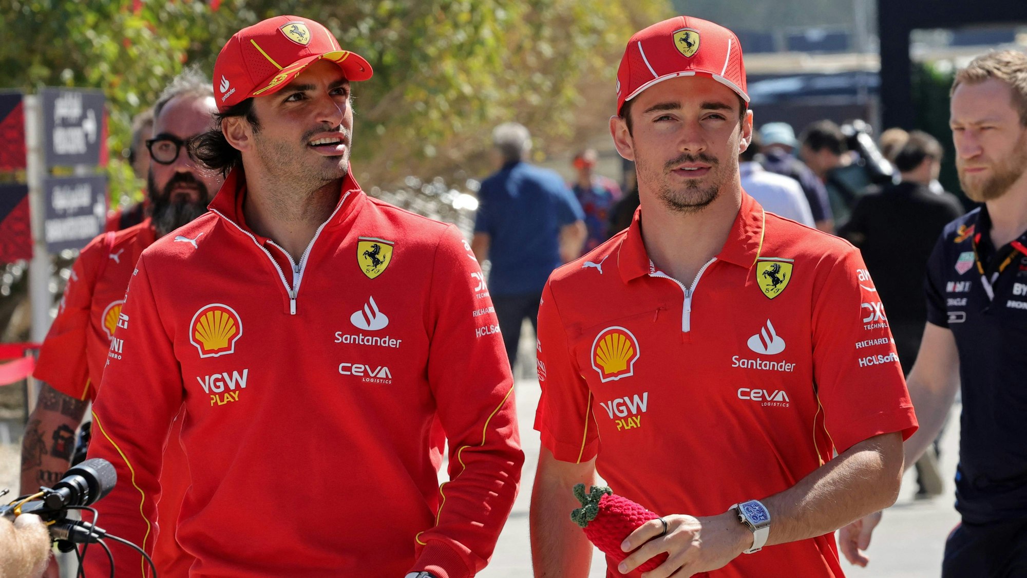 Carlos Sainz und Charles Leclerc gehen gemeinsam durch das Fahrerlager.