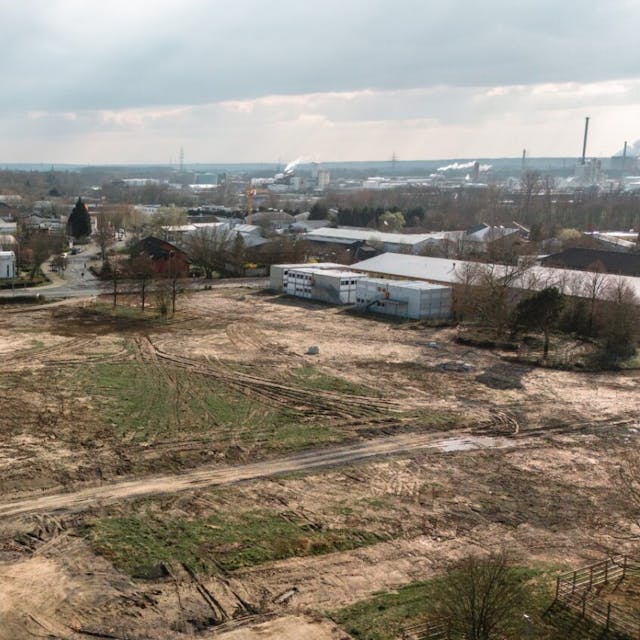 Ein Luftbild zeigt das freigeräumte, mehr als zwei Hektar große Grundstück an der Berliner Straße in Niederkassel-Lülsdorf, auf dem bis zum dritten Quartal 2026 der Erweiterungsbau für das Schulzentrum Nord entstehen soll.