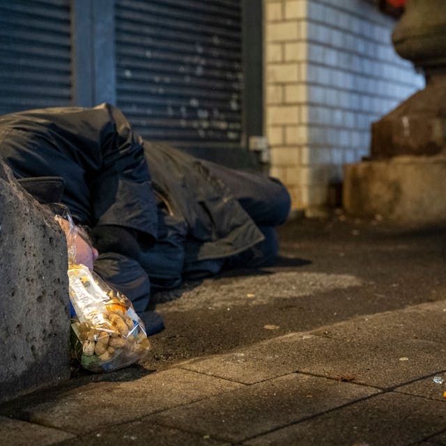 Ein wohnungsloser Mann schläft in Köln auf der Straße (Symbolbild)