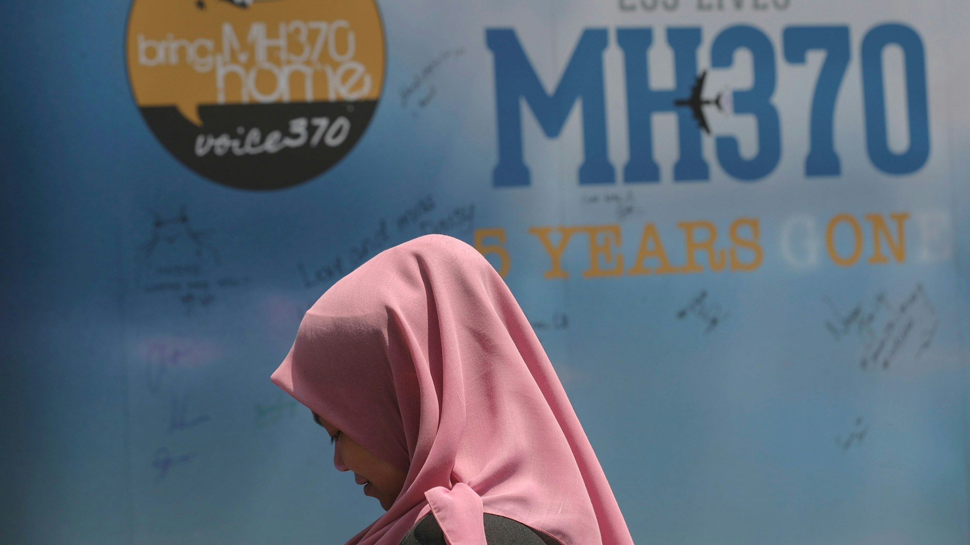 Ein Mädchen steht während eines Gedenktages für das verschwundene Flugzeug MH370 vor einer Kondolenztafel. (Archivbild)
