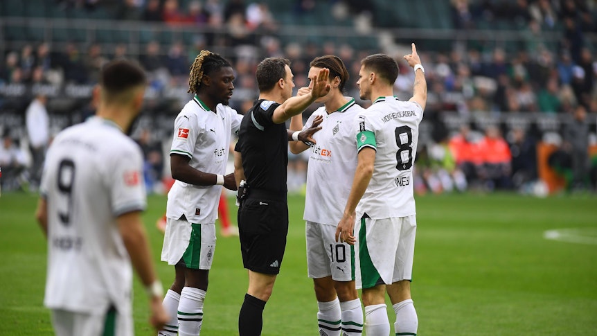 Felix Zwayer umringt von Borussia-Spielern.