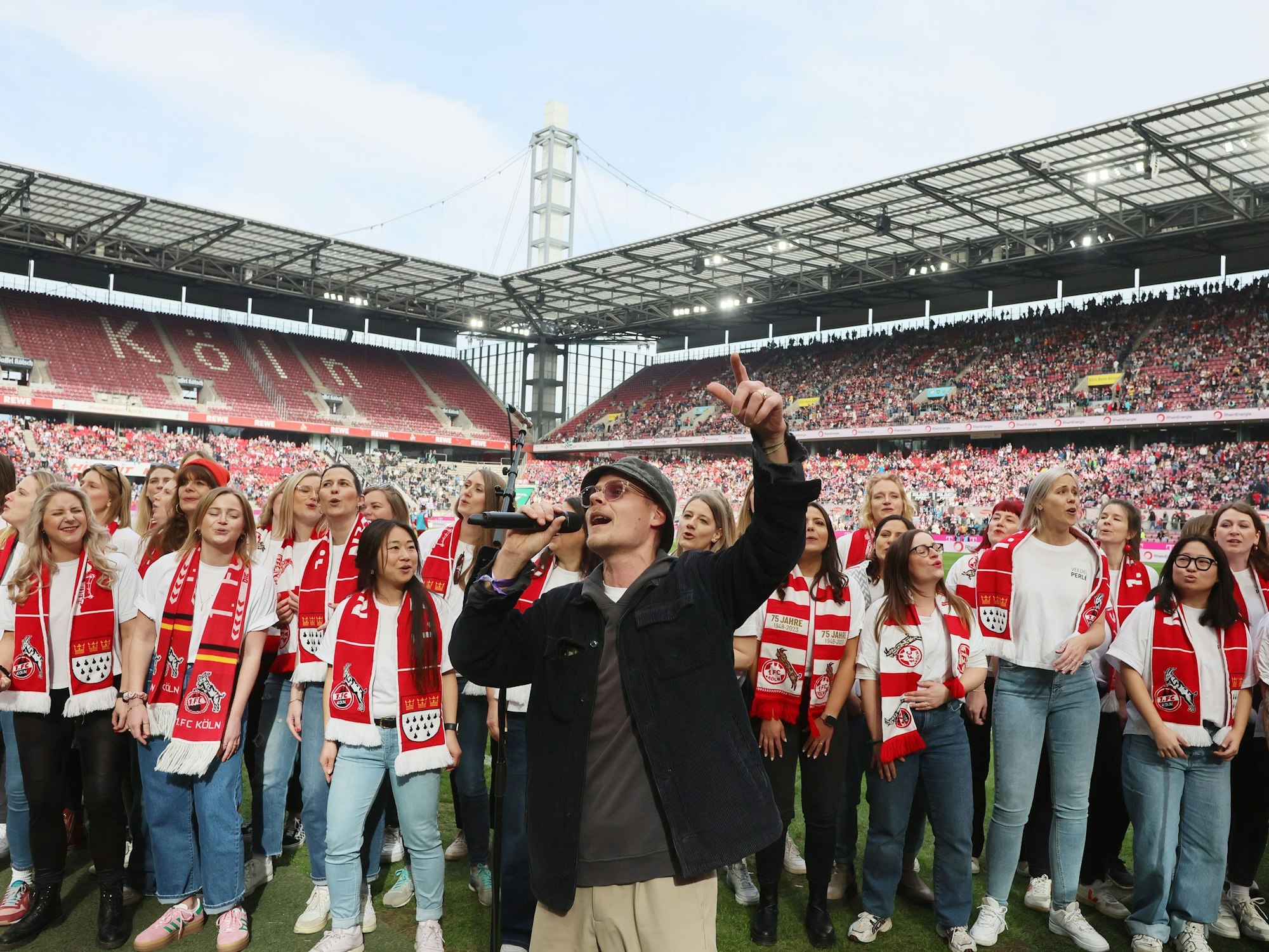 Oliver Niesen singt gemeinsam mit einem Frauen-Chor im Stadion.