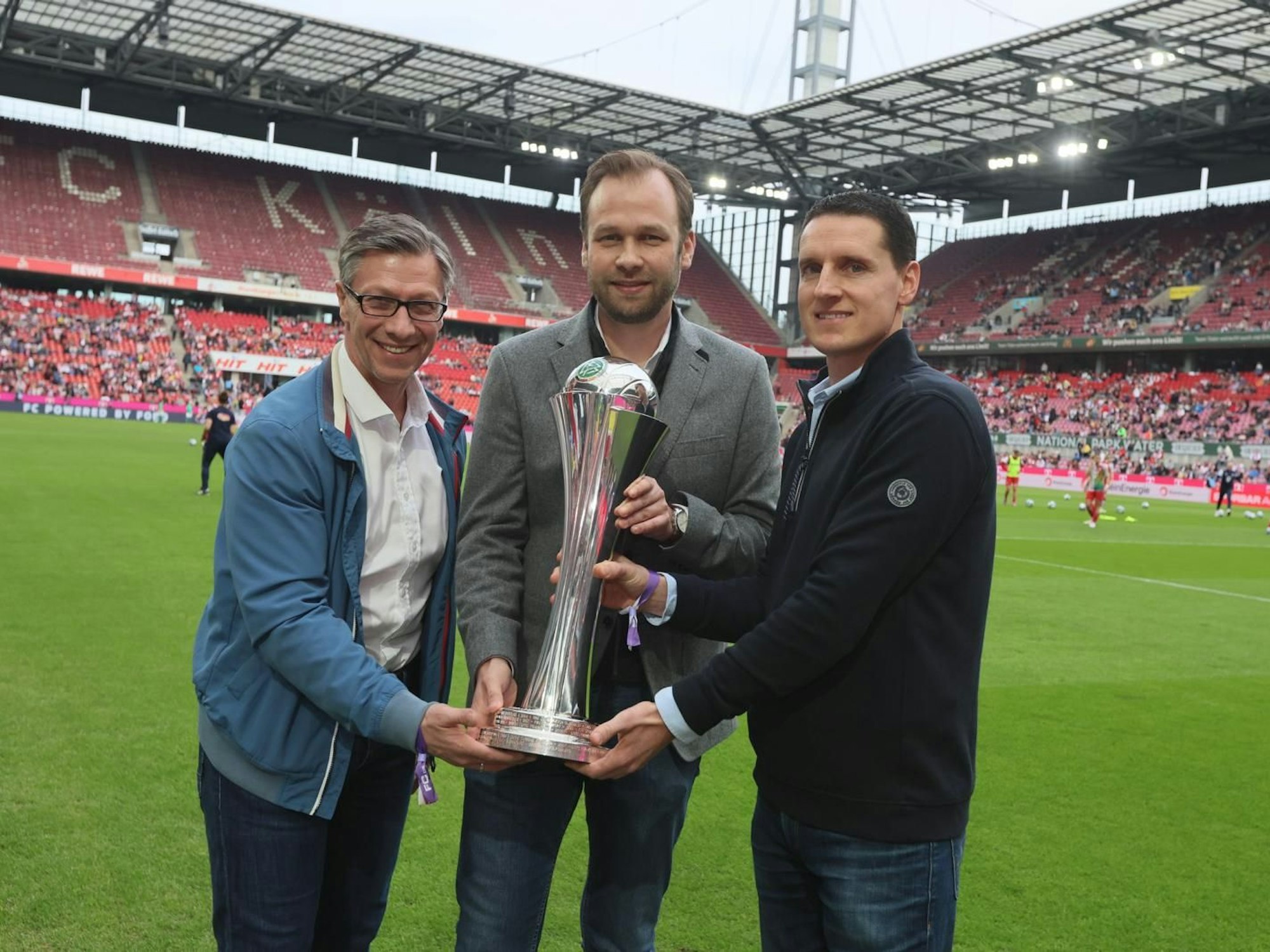 Von links: Dr. Christos Katzidis (FVM), Robert Voigtsberger von der Stadt Köln und Manuel Hartmann vom DFB bei der Übergabe des DFB-Pokals an die Stadt vor dem Spiel.