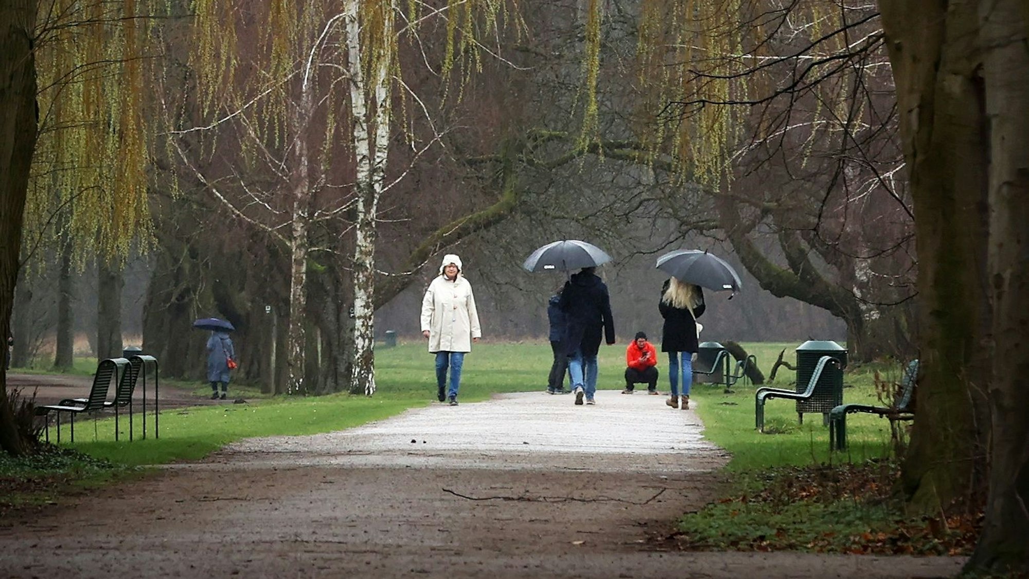 Mehrere Spaziergänger gehen am Decksteiner Weiher in Köln durch den Regen. Für Köln und die Region werden ab Sonntag (10. März) schwere Unwetter und Regenfälle erwartet. (Archivbild)