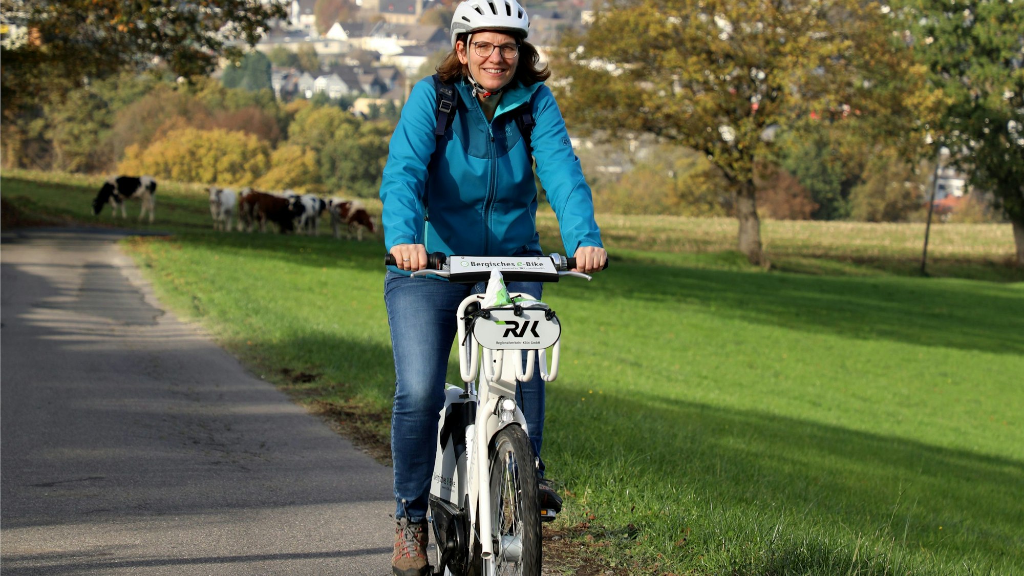 Eine Frau fährt mit einem E-Bike durch die bergische Landschaft in Overath.