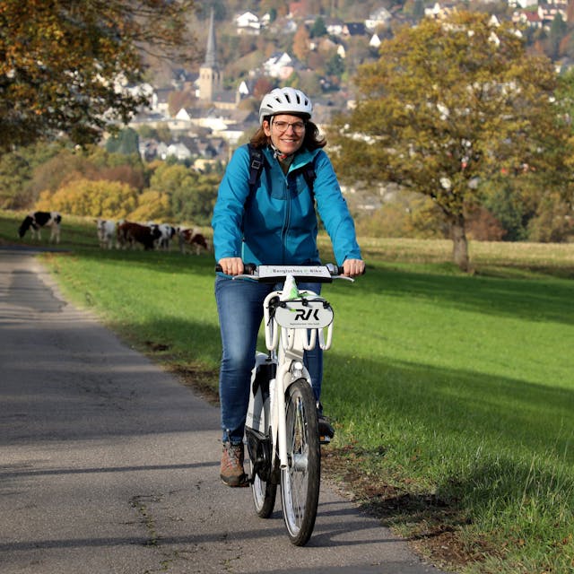 Eine Frau fährt mit einem E-Bike durch die bergische Landschaft in Overath.&nbsp;