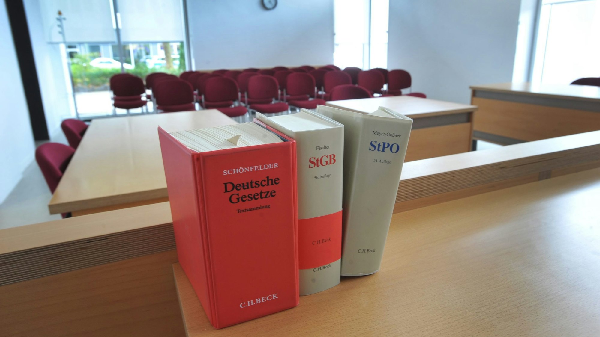 Ein Sitzungssaal im Amtsgericht Leverkusen in Opladen, im Vordergrund drei Bände mit Gesetzestexten