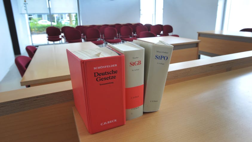 Ein Sitzungssaal im Amtsgericht Leverkusen in Opladen, im Vordergrund drei Bände mit Gesetzestexten