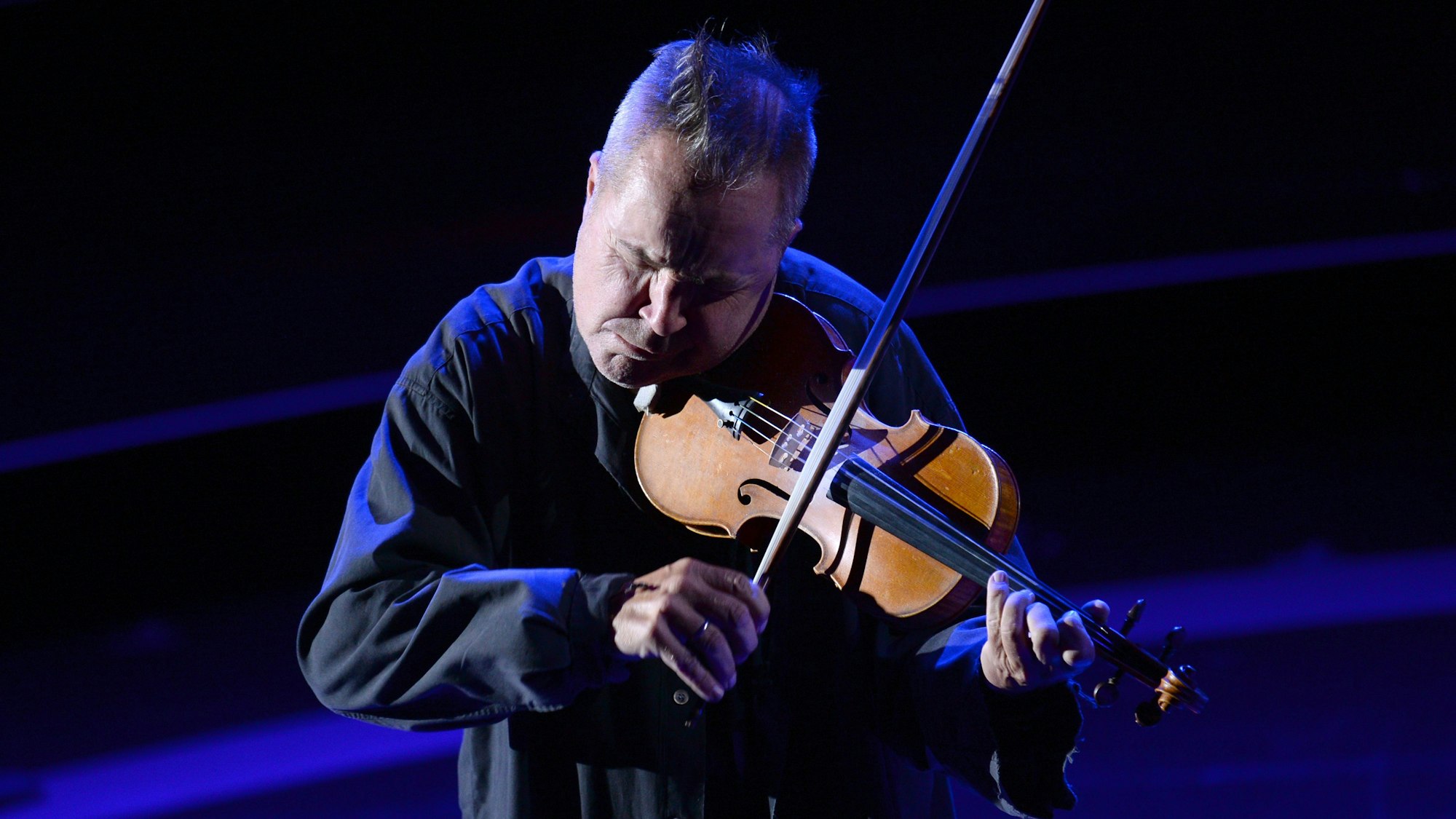 Nigel Kennedy mit seiner Geige auf der Bühne bei einem Konzert.