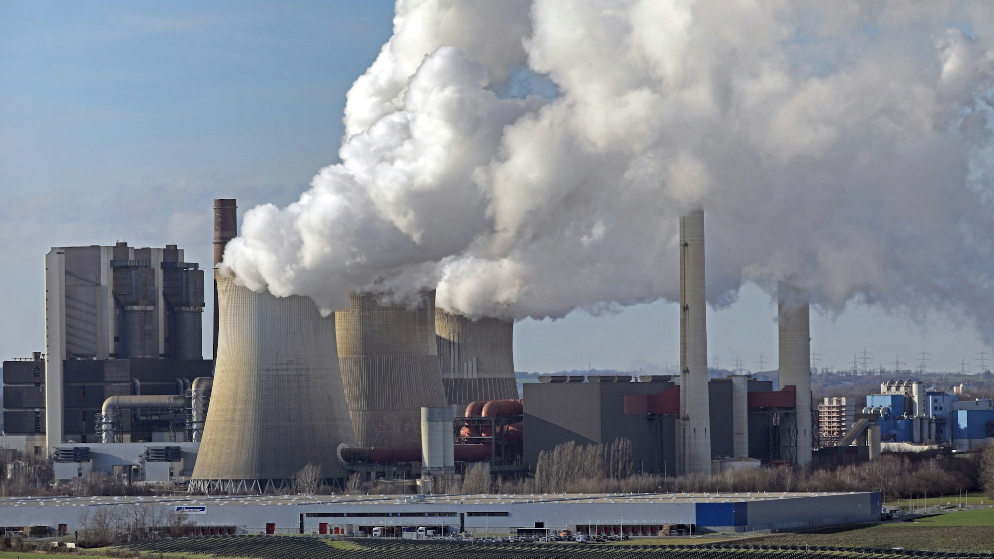 Eschweiler: Aus dem RWE-Kraftwerk Weisweiler steigt Dampf und Rauch. Das alte Braunkohlekraftwerk soll nach der Einigung von Bund und Ländern zum Kohleausstieg bald vom Netz gehen.