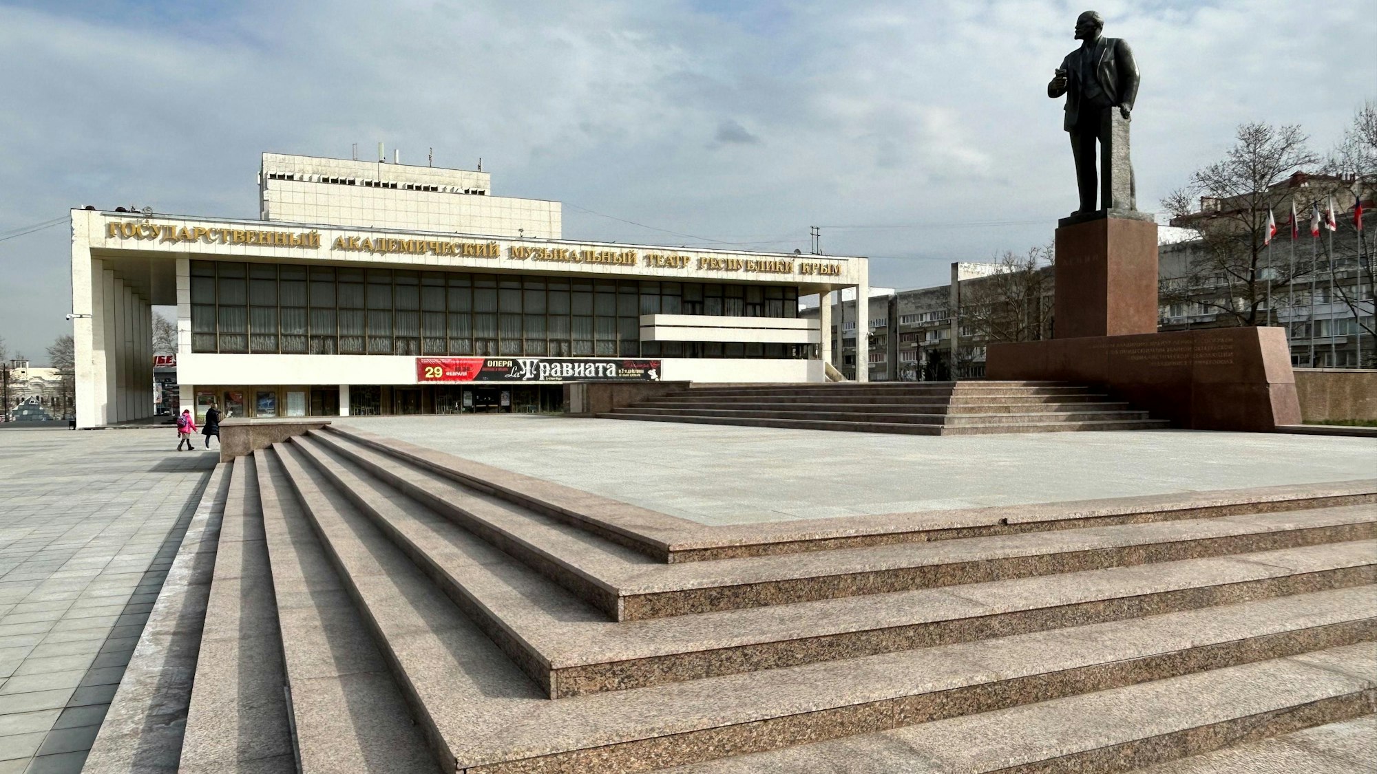 Ukraine, Simferopol: Im Zentrum der Hauptstadt der Schwarzmeer-Halbinsel Krim erinnert wie zu Sowjetzeiten vor mehr als 30 Jahren ein Lenin-Denkmal an den Revolutionsführer von 1917. Im Hintergrund steht das Staatliche Akademische Musiktheater der Republik Krim.