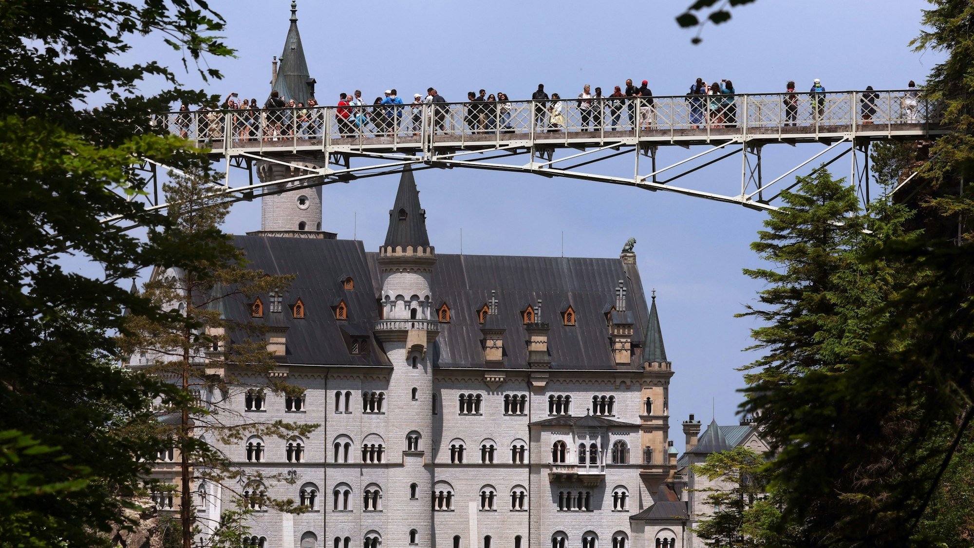 Touristen stehen auf der Marienbrücke vor dem Schloss Neuschwanstein. Ein Mann hatte am 14. Juni 2023 zwei Touristinnen in der Nähe von Schloss Neuschwanstein in eine Schlucht gestoßen. Eine der beiden Frauen starb an ihren Verletzungen. (Archivbild)