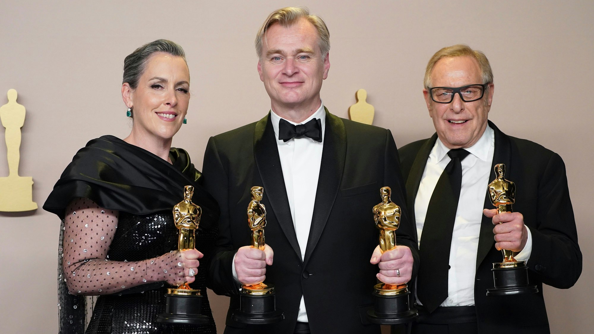 Emma Thomas, Christopher Nolan (m) und Charles Roven posieren im Presseraum mit dem Preis für den besten Film für „Oppenheimer“ bei der Oscar-Verleihung.