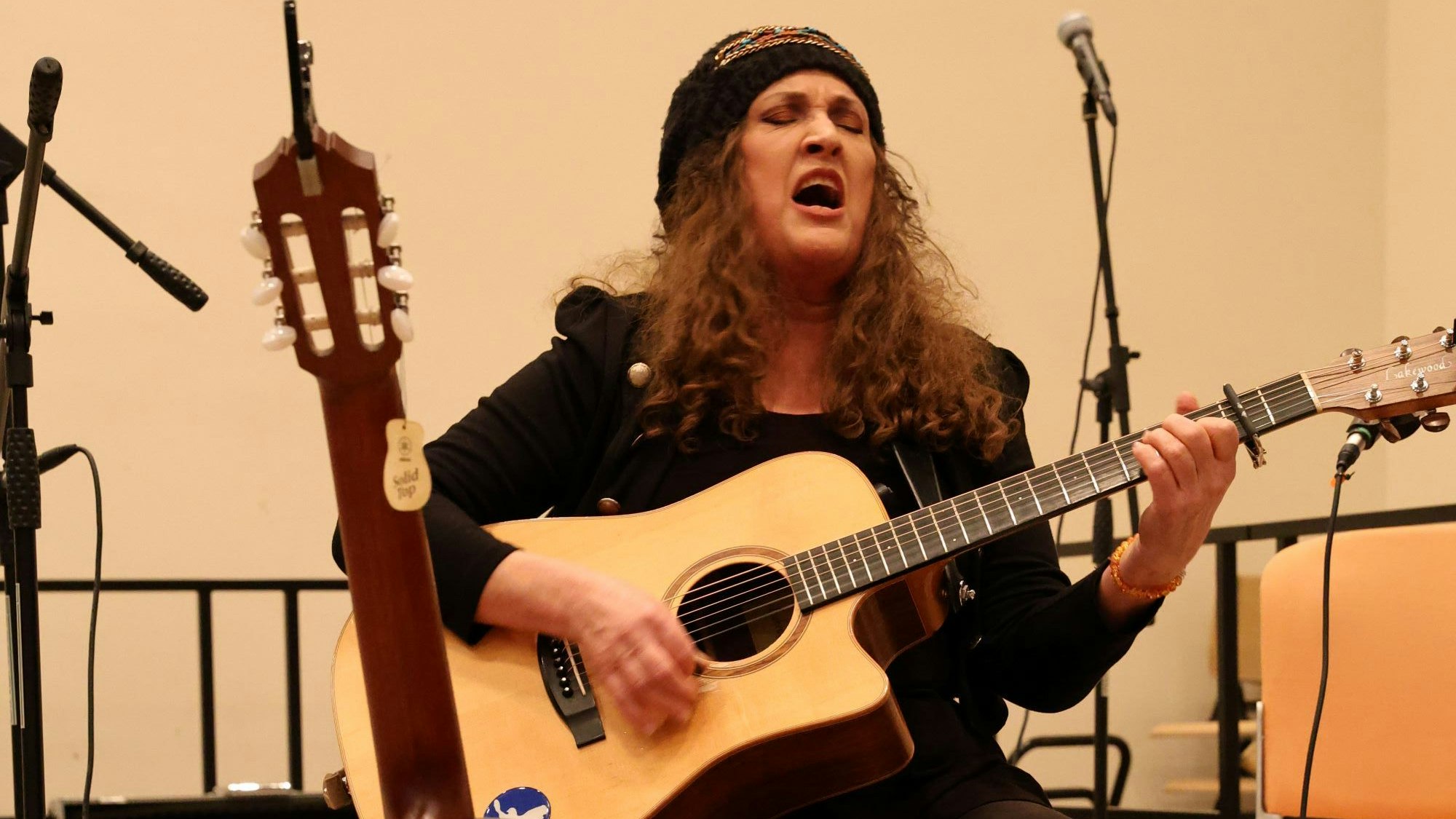 Eine Frau singt und spielt Gitarre.