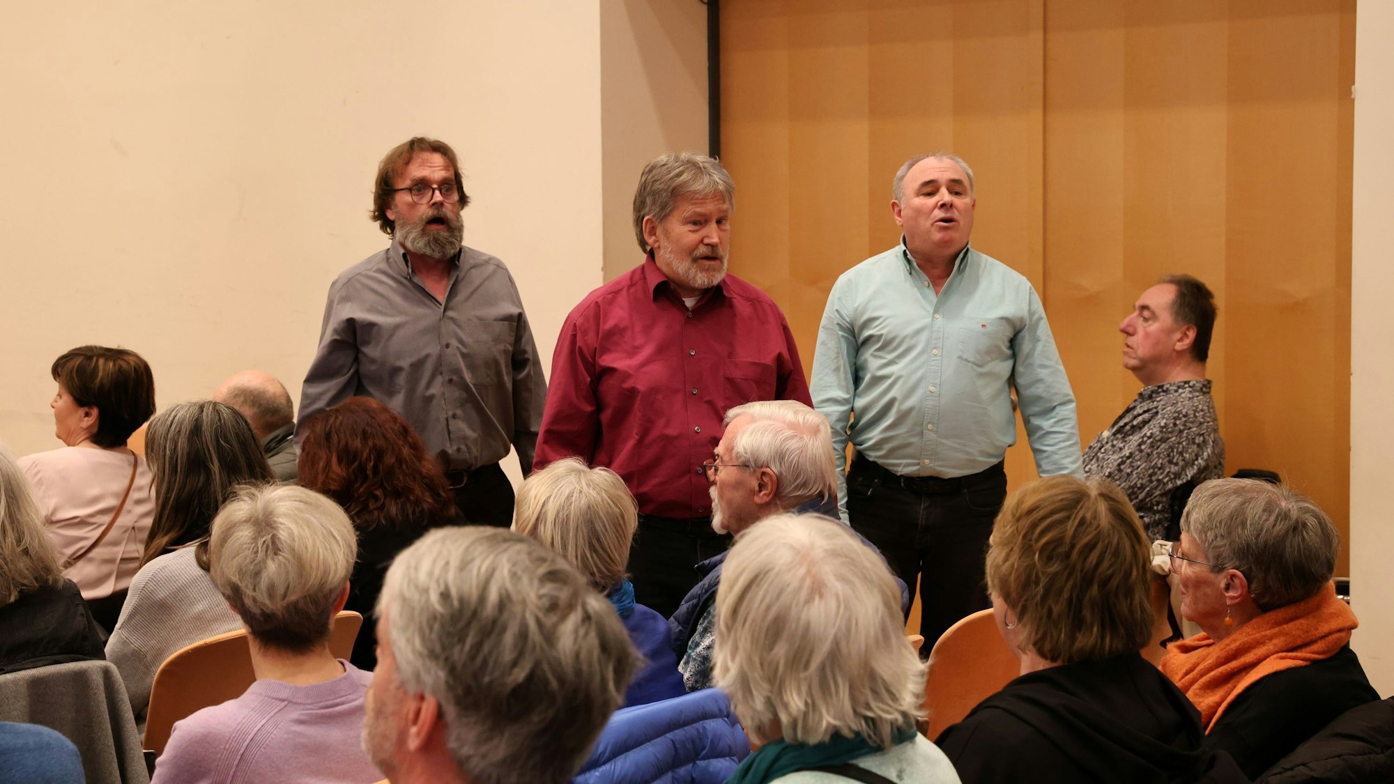 Vor Publikum singen drei Männer.