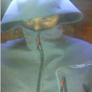 Das Foto zeigt einen Mann, dessen Gesicht zum größten Teil von der Jacke verdeckt ist.